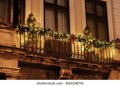 Stylish christmas tree, branches, ornaments in lights illumination on balcony of building in evening. Atmospheric magic time. Christmas festive decor for winter holidays. Merry Christmas! - Powered by Shutterstock