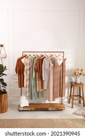 Stylish clothes hanging on rack in dressing room. Interior design