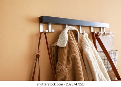 Stylish clothes hanging on wall in hall