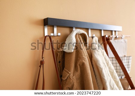 Stylish clothes hanging on wall in hall