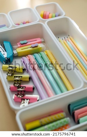 Stylish colored stationery in pastel colors is arranged in white organizers. Creative Drawer Organizing. Storage office supplies. Concept back to school.