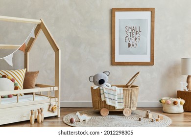 Stylish composition of cozy scandi child's room interior with mock up poster frame, bed, rattan basket, plush and wooden toys and decorations. Creative wall, carpet on the floor. Copy space. 
