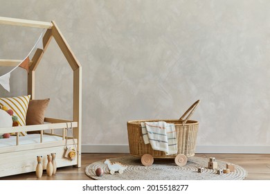 Stylish composition of cozy scandinavian child room interior with bed, rattan basket, plush and wooden toys and textile hanging decorations. Creative wall, carpet on the floor. Copy space. Template.