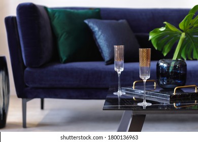 Stylish Composition At Living Room Interior With Velvet Sofa, Pillows, Coffee Table, Tropical Leaf, Wine Glasses And Decoration In Modern Concept.