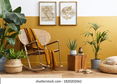 Stylish composition of living room interior with design rattan armchair, two mock up poster frames, plants, cube, palid and personal accessories in honey yellow home decor. Template. - Shutterstock ID 1820202062