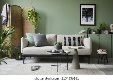 Stylish composition of modern living room interior. Mock up poster frame, modern sofa, folding screen, plants and personal accessories. Eucalyptus wall. Home staging. Template. Copy space. 