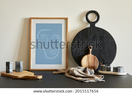 Stylish composition of modern small dining space interior. Black table, black and light wooden kitchen and dining accessories. Neutral walls. Minimalistic masculine concept. Details. Template.