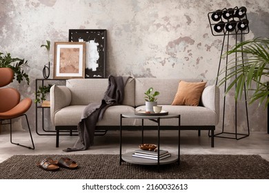 The stylish compostion at living room interior with design gray sofa, wooden coffee table, brown armchair and elegant personal accessories. Loft and industrial interior. Home decor. Template. 
