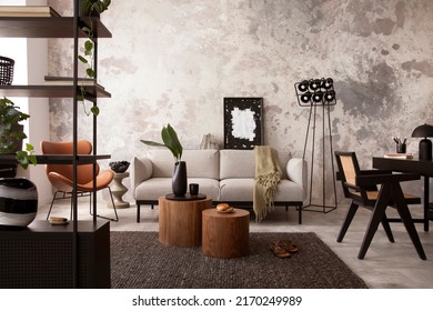 The stylish compostion at living room interior with design gray sofa, wooden coffee table, desk and elegant personal accessories. Loft and industrial interior. Home decor. Template. 