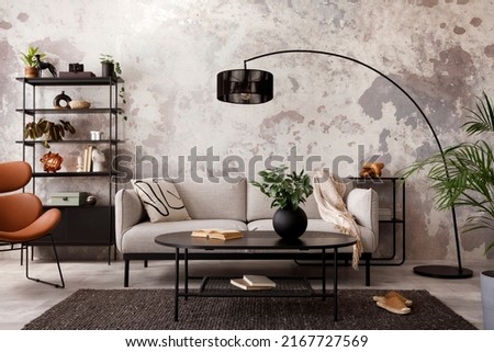 The stylish compostion at living room interior with design gray sofa, armchair, black coffee table, lamp and elegant personal accessories. Loft and industrial interior. Template. 
