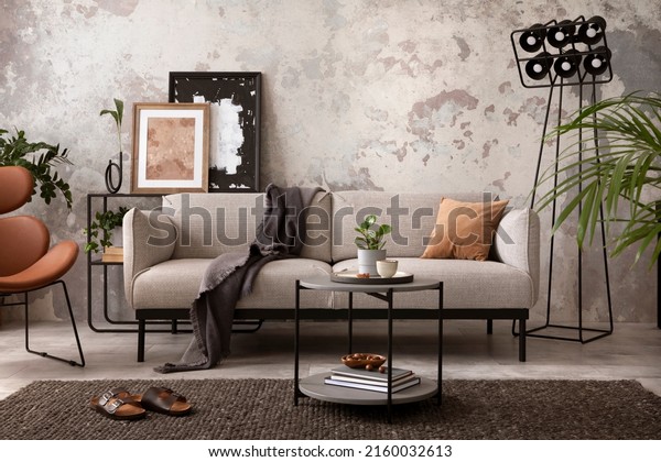The stylish composition at living room interior wallpaper, with design gray sofa, wooden coffee table, brown armchair and elegant personal accessories. Loft and industrial interior. Home décor. Template. 