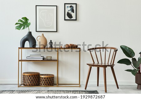 Stylish concept of living room interior with mock up poster frames, wooden console, chair, tropical leaf in vase, rattan baskets, plant, carpet and personal accessories in home decor. Template.