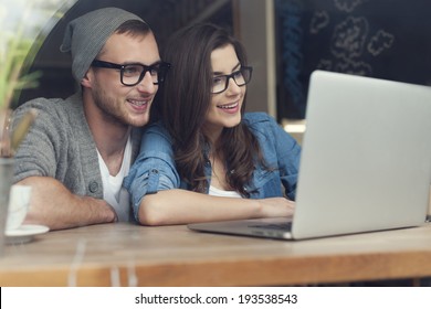 Stylish couple with contemporary laptop in cafe   - Powered by Shutterstock