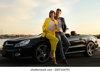 Stylish Couple Near Luxury Convertible Car Outdoors