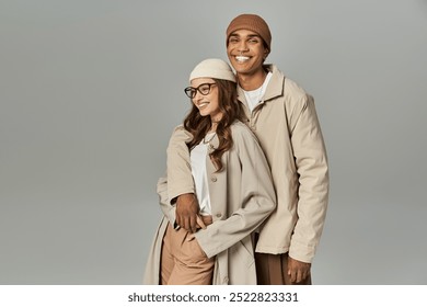 A stylish couple poses playfully, showcasing vibrant autumn attire against a soft background. - Powered by Shutterstock