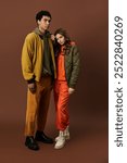 A stylish couple showcases trendy autumn outfits in rich, vibrant colors, exuding warmth.