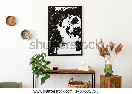 Stylish and cozy scandinavian interior of living room with wooden console, rings on the wall, cube, plants and elegant personal accessories. Black mock up poster map. Design home decor. Template. 