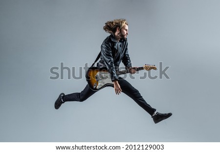 stylish crazy man. musical instrument. emotional bearded rocker in leather jacket.