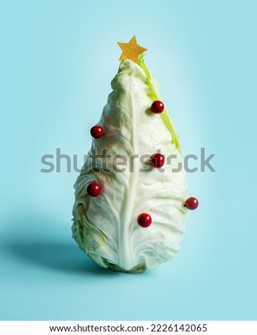 stylish creative new year layout with a cabbage
 in the shape of a Christmas tree with decorations on a pastel blue background. new year food concept or creative postcard. copy space
