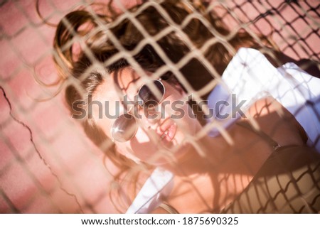 Young surfer woman with top and bikini kissing surfboard