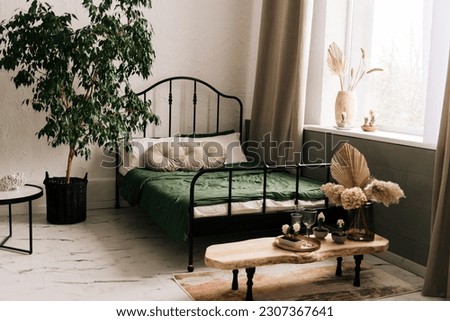 Stylish decor with a black wrought-iron bed and beautiful decor details, geocints, vases, flowers and beautiful textiles