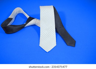 stylish design black and white colour tie folded isolated over blue background close up view single object concept noperson 