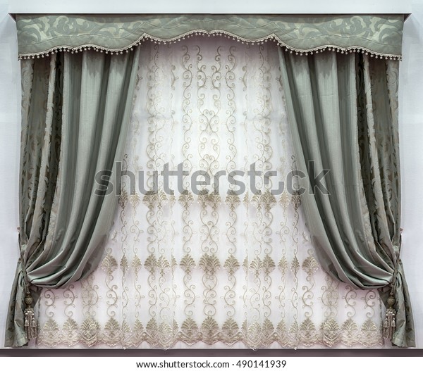 The stylish design of the windows in the\
interior. Combined curtains made of the natural fabrics. A hard\
pelmet and a tulle with\
embroidery