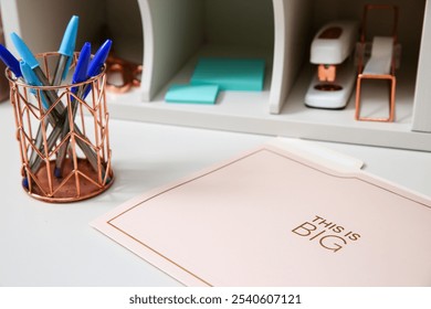 Stylish desk setup featuring rose gold stationery, a collection of pens, and organized office supplies, perfect for a modern workspace - Powered by Shutterstock