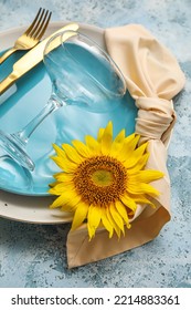 Stylish Dinnerware And Sunflower On Blue Table