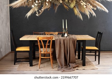 Stylish Dinning Room With Wooden Table And Chairs. Holiday Family Dinner. Kitchen Interior With Furniture. Living Room WithComposition Dry Decoration Plant On Wall. Cozy Room Decorated With Fall Decor