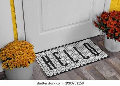 Stylish Door Mat With Word Hello And Beautiful Flowers On Wooden Floor