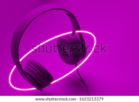 Stylish earphones. 80's synth wave and retrowave glowing ellipse futuristic aesthetics. Old fashioned abstraction concept