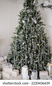 Stylish Elegant Christmas Tree Decorated In White With Garlands And Gifts In The Living Room. Concept: Christmas, December 25, Stylish House