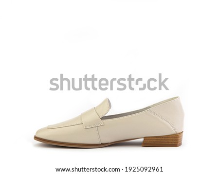 Stylish and elegant ivory women's loafers. Trendy flat leather shoes with square toe and beige sole. Isolated close-up on white background. Left side view. Fashion shoes.