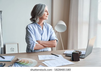 Stylish Elegant Mature Business Woman Fashion Designer Thinking On New Creative Ideas At Workplace Standing With Arms Crossed Looking Through Window. Classy Middle Aged Older Lady Dreaming In Atelier.