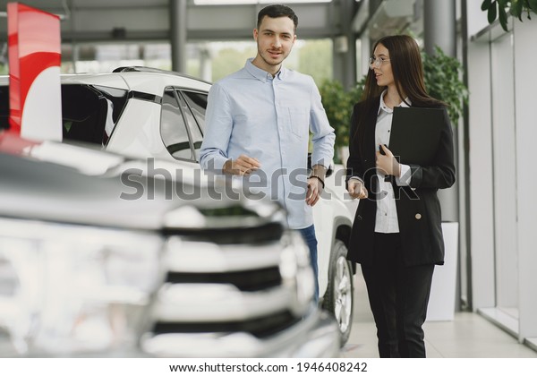Stylish and elegant\
people in a car salon