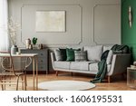 Stylish emerald green and grey living room interior design with abstract painting on the wall
