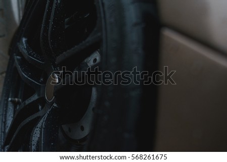 Stylish and expensive sports car closeup. Raindrops on a beautiful brown car. Black stylish sportcar alloy wheels with sports tires closeup