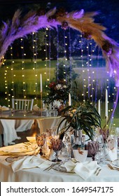 stylish and expensive wedding decor, table setting using gold, candles, lights, flowers, chic glasses and plates