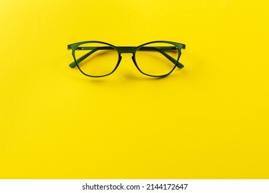 Stylish eyeglasses over yellow background. Optical store, glasses selection, eye test, vision examination at optician, fashion accessories concept. Space for text.