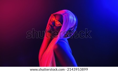 Stylish fashion african teenager model wearing headphones listening dj music dancing in purple neon lights. Young teen girl enjoy cool music 90s party mix in violet studio background.