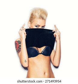 Stylish fashion blonde girl with tattoo in a black t-shirt showing his chest. White background, not isolated