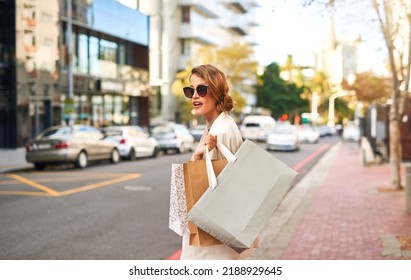 Stylish Fashion Model Shopping In The City And Walking Outdoors With Bags. Young, Edgy And Carefree Female With An Expensive Lifestyle Standing In The Street With Bags In An Urban Town