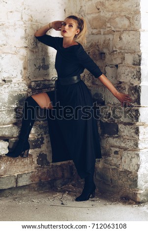 Stylish fashionable girl with blonde long hair,  stylish black dress. Fashion trendy woman concept