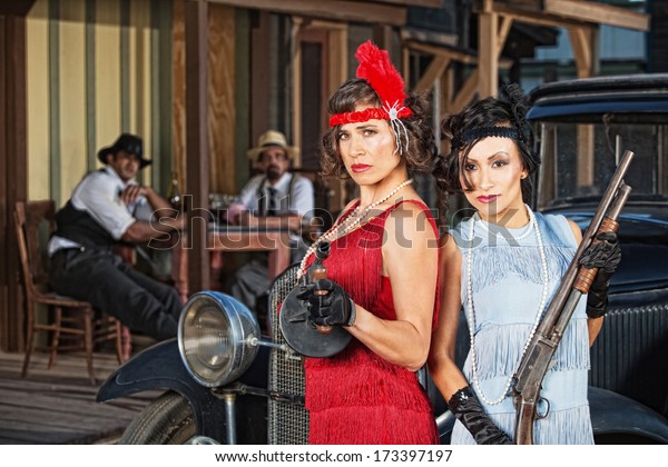 Stylish female 1920s\
gangsters with weapons