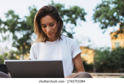 Stylish Female Entrepreneur Working With Modern Laptop Outdoor In Summer At City Park. Young Professional Woman Looking Monitor Using Tablet Outside.