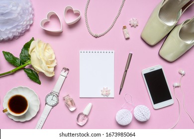 Stylish feminine accessories, bridal decorative items, shoes, jewellery, rose flower, hearts on pink background. Empty notebook page, wedding invitation. Flat lay, top view, copy space, mock up
