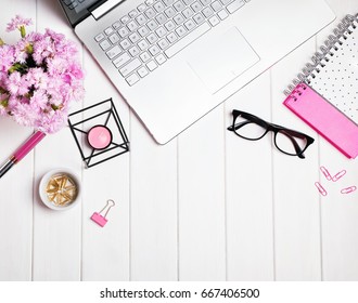 Stylish feminine workplace with flowers, top view