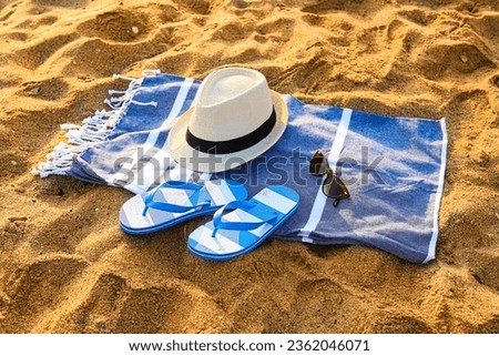 Stylish flips flops with beach accessories on sand at resort