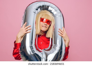 A Stylish, Funny Woman Stands With A Silver Balloon In The Form Of The Number Zero And Happily Smiles With Her Head Stuck Into The Balloon